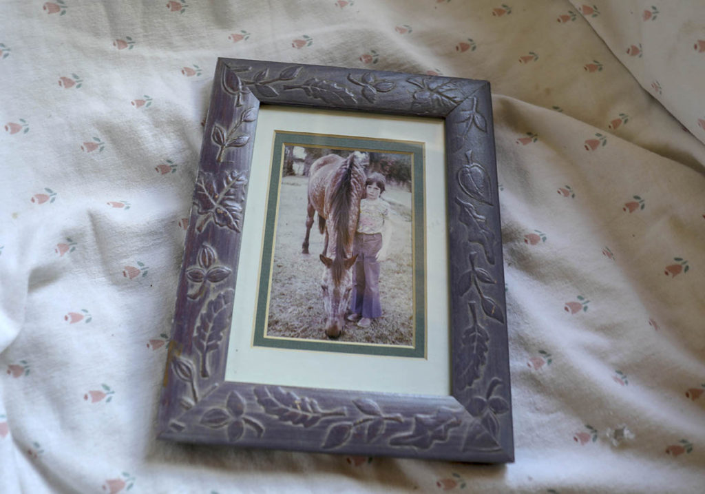 A framed photograph of a young girl and a horse.